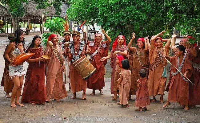 Integrantes de una comunidad nativa con vestimenta tradicional, tambor y danza en la selva, eje Comunidades Nativas del borrador programático de Junín 2026